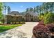Elegant stone home featuring manicured landscaping and a spacious driveway leading to a grand entrance at 9011 Pine Laurel Dr, Weddington, NC 28104