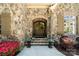 Charming stone facade featuring a wood front door with sidelights and decorative planters at 9011 Pine Laurel Dr, Weddington, NC 28104