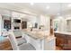 Bright kitchen has white cabinets, granite countertops, hardwood floors and bar seating overlooking living room at 9011 Pine Laurel Dr, Weddington, NC 28104