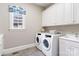 Well-equipped laundry room with modern washer and dryer, storage, and ample countertop space at 9011 Pine Laurel Dr, Weddington, NC 28104