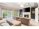 Inviting living room features a cozy fireplace, built-in bookshelves and sun-filled windows with views of the outdoors at 9011 Pine Laurel Dr, Weddington, NC 28104