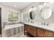 Bathroom with a double sink vanity, a tub under a window, and updated fixtures at 10429 Madison Park Dr, Charlotte, NC 28269