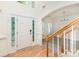 Bright entryway featuring a hardwood floor and a staircase with wooden railing at 10429 Madison Park Dr, Charlotte, NC 28269