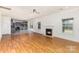 Bright living room featuring a fireplace, wood floors, and kitchen view through the wide opening at 10429 Madison Park Dr, Charlotte, NC 28269