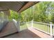 Outdoor deck with wooden planks and white railings overlooking lush green trees and well manicured lawn at 118 Lakewood Dr, Kings Mountain, NC 28086