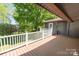 Outdoor wooden deck with white railings offering views of the greenery and a house in the distance at 118 Lakewood Dr, Kings Mountain, NC 28086