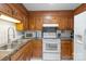 Charming kitchen with wood cabinets, white appliances, and black countertops at 118 Lakewood Dr, Kings Mountain, NC 28086