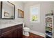 Half bath featuring a granite vanity, decorative mirror, white toilet, and gray walls at 125 Trent Pines Dr, Mooresville, NC 28117