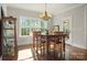Dining room with hardwood floors, a traditional table and chairs, chandelier, and natural light from the large windows at 125 Trent Pines Dr, Mooresville, NC 28117