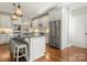 Well-lit kitchen with stainless steel appliances, white cabinets, a breakfast bar, and hardwood floors at 125 Trent Pines Dr, Mooresville, NC 28117