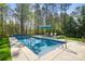 Relaxing pool area with an in-ground pool, lounge chairs, umbrella, and a beautiful treed backyard at 125 Trent Pines Dr, Mooresville, NC 28117