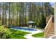 Backyard oasis featuring a pool, manicured lawn, and a wooded backdrop, creating a private retreat at 125 Trent Pines Dr, Mooresville, NC 28117