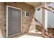 Stylish gray front door with brick surround, offering a warm welcome to the home at 1268 Scotch Meadows Loop, Monroe, NC 28110