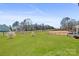 Spacious backyard with lush green grass, partial fence, and a serene view under a blue sky at 128 Stibbs Cross Rd, Mooresville, NC 28115