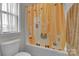 Bathroom with a whimsical llama-themed shower curtain and a soaking tub at 128 Stibbs Cross Rd, Mooresville, NC 28115