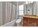 Bathroom features a tub with shower, neutral paint color, and a dark wood vanity at 128 Stibbs Cross Rd, Mooresville, NC 28115