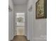 Hallway leading to a bathroom with double sinks, white cabinets, and recessed lights at 128 Stibbs Cross Rd, Mooresville, NC 28115