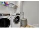 Laundry room with modern washer and dryer, storage shelves, and hardwood floors at 128 Stibbs Cross Rd, Mooresville, NC 28115