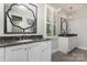 Stylish bathroom with double vanities featuring granite countertops and decorative mirrors at 13620 Castleford Dr, Mint Hill, NC 28227