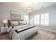 Bright bedroom featuring a plush bed with decorative pillows, ample natural light, and stylish light fixture at 13620 Castleford Dr, Mint Hill, NC 28227
