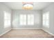 Well-lit bedroom featuring large windows with shutters and a modern light fixture at 13620 Castleford Dr, Mint Hill, NC 28227