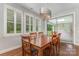 Formal dining room with a wood table, chairs, and shuttered windows overlooking the backyard at 13620 Castleford Dr, Mint Hill, NC 28227