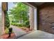 View from the front porch of a brick house, showcasing the landscaped walkway and lush greenery at 13620 Castleford Dr, Mint Hill, NC 28227