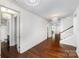 Bright hallway with hardwood floors leading to staircase and doorways at 13620 Castleford Dr, Mint Hill, NC 28227