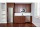 A second kitchen featuring stainless appliances, wood cabinetry, marble counters, and sink at 13620 Castleford Dr, Mint Hill, NC 28227