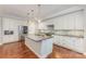 Modern kitchen featuring white cabinets, stainless steel appliances, and center island at 13620 Castleford Dr, Mint Hill, NC 28227