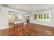 Open-concept living area with hardwood floors, natural light, and kitchen view at 13620 Castleford Dr, Mint Hill, NC 28227