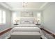 Serene main bedroom featuring a tray ceiling, hardwood floors, and large windows for plenty of light at 13620 Castleford Dr, Mint Hill, NC 28227