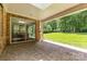 Covered brick patio with a view of the lush, green backyard and outdoor living space at 13620 Castleford Dr, Mint Hill, NC 28227