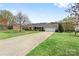 Well manicured lawn and brick ranch home with long driveway leading to an attached garage at 139 Meadow Oaks Dr, Statesville, NC 28625