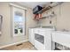 Bright laundry room featuring a window, sink, washer, dryer, and shelving at 139 Meadow Oaks Dr, Statesville, NC 28625