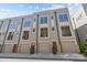 View of the townhouse exterior featuring multiple windows and garage doors for each unit at 1617 Cannon View Ln, Charlotte, NC 28208