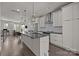Open-concept kitchen boasts white cabinetry, an island with a sink, and flows seamlessly into the living space at 1617 Cannon View Ln, Charlotte, NC 28208