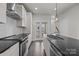 Well-lit modern kitchen with white cabinets, black countertops, stainless steel appliances, and hardwood floors at 1617 Cannon View Ln, Charlotte, NC 28208