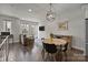 Open concept living and dining area featuring hardwood floors and a modern chandelier with an adjacent sofa at 1617 Cannon View Ln, Charlotte, NC 28208