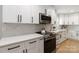 Close-up of a modern kitchen with white cabinets, a stainless steel oven, quartz countertops, and hardwood floors at 1812 Lot 2 Anderson St, Charlotte, NC 28205
