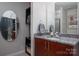 Granite-counter vanity with oval mirror and decorative shelves at 210 N Church St # 1307, Charlotte, NC 28202
