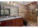 Bathroom with a double vanity, granite countertop, and walk-in shower at 210 N Church St # 1307, Charlotte, NC 28202