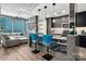 Modern condo kitchen featuring wood floors, concrete ceilings, stainless appliances, and city views at 210 N Church St # 1307, Charlotte, NC 28202