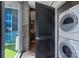 Modern laundry area with stacked washer and dryer units, located off a balcony and next to an interior room at 210 N Church St # 1307, Charlotte, NC 28202