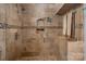Walk-in shower featuring natural stone and tiled walls at 210 N Church St # 1307, Charlotte, NC 28202