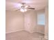 A light-filled bedroom with neutral walls and carpet, ceiling fan, and a closet at 2131 Wildlife Rd, Charlotte, NC 28214