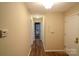 Inviting hallway with wood floors, leading to multiple rooms, and thermostat control at 2131 Wildlife Rd, Charlotte, NC 28214