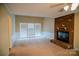 Bright living room with a brick fireplace, wainscoting, and windows overlooking the backyard at 2131 Wildlife Rd, Charlotte, NC 28214