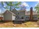 Exterior view showcasing a deck, sliding doors, brick chimney, and well-maintained lawn at 2439 Heathershire Ln, Matthews, NC 28105