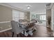 Elegant dining room with a large table, upholstered chairs, and a view into the adjacent living room at 2439 Heathershire Ln, Matthews, NC 28105